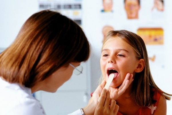 врач осматривает горло девочки